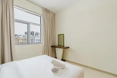 a white bedroom with a bed and a window at RH-Prime Location , Spacious 1 Bedroom near Mall of the Emirates in Dubai