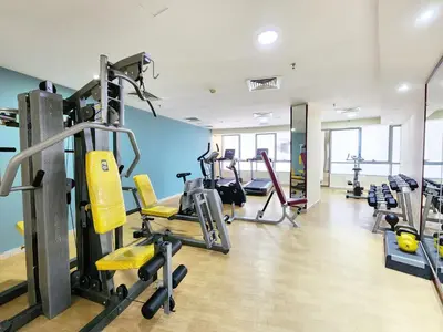 a gym with treadmills and machines in a room at RH-Prime Location , Spacious 1 Bedroom near Mall of the Emirates in Dubai