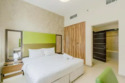 a bedroom with a large white bed and a green wall at RH- Huge, Comfortable 01 BR Apartment in Barsha1 in Dubai