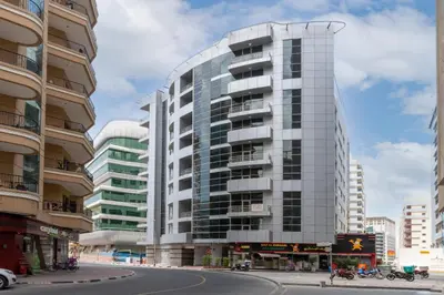 a tall glass building on a city street at RH- Huge, Comfortable 01 BR Apartment in Barsha1 in Dubai