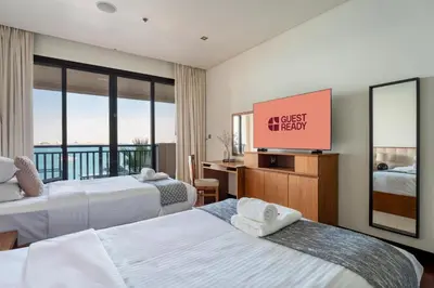 a hotel room with two beds and a flat screen tv at GuestReady - A Glimpse of Burj Al Arab in Dubai