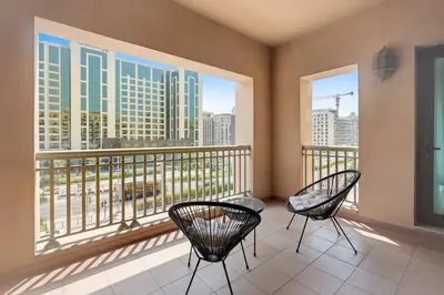 two chairs on a balcony with a view of the city at StoneTree - Golden Mile 5 2BR - Near Nakhil Mall in Dubai