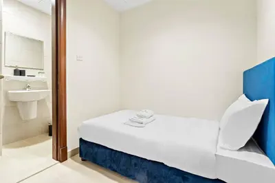 a small room with a bed and a sink at StoneTree - Golden Mile 4 2 BR - Supreme Residences in Dubai