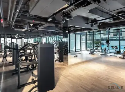 a gym with treadmills and exercise equipment in a building at Polished 1BR at Binghatti Creek Al Jadaf by Deluxe Holiday Homes in Dubai