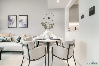 a white living room with a table and chairs at Polished 1BR at Binghatti Creek Al Jadaf by Deluxe Holiday Homes in Dubai