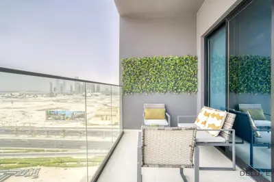 a balcony with chairs and a view of an airport at Polished 1BR at Binghatti Creek Al Jadaf by Deluxe Holiday Homes in Dubai
