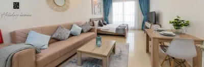 a living room with a couch and a table at Mira Holiday Homes - Beautiful Studio in Living Legends in Dubai