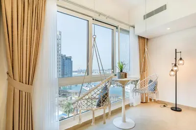 a room with large windows and a table and chairs at Marina Residences 2BR: Seaside in Palm Jumeirah in Dubai
