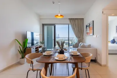 a dining room and living room with a table and chairs at Vacationer l 1 Bedroom on Low Floor l Close to Burj Khalifa l Pool Access & Free Wi-Fi in Dubai