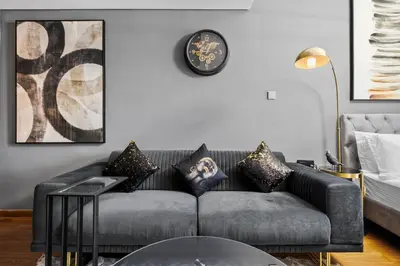 a living room with a couch and a clock on the wall at Luxury studio at JLT near metro in Dubai