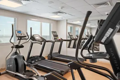 a row of treadmills in a gym at Stylish studio at Sports City in Dubai