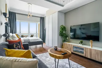 a living room with a couch and a tv at Upscale studio at JLT near metro in Dubai