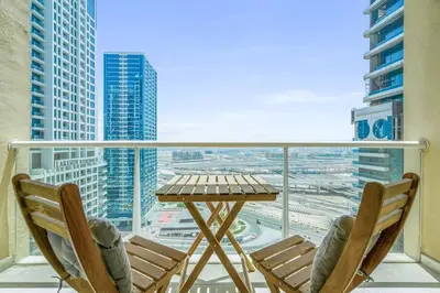 a table and chairs on a balcony with a view of a city at Upscale studio at JLT near metro in Dubai