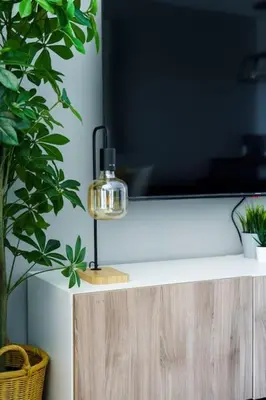 a lamp sitting on top of a cabinet with a tv at Upscale studio at JLT near metro in Dubai