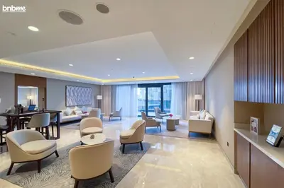 a lobby of a hotel with chairs and a table at bnbme - Luxury 1BR Apt w Burj Khalifa Views Pool Gym & Prime Location Near Dubai Mall in Dubai