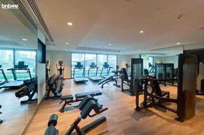 a gym with a lot of treadmills and machines at bnbme - Luxury 1BR Apt w Burj Khalifa Views Pool Gym & Prime Location Near Dubai Mall in Dubai