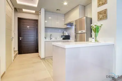 a kitchen with a counter with a vase of flowers at Magnificent 3BR Townhouse at DAMAC Hills 2, Dubailand by Deluxe Holiday Homes in Dubai
