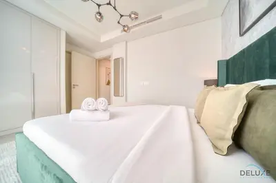 a bedroom with a bed with two towels on it at Magnificent 3BR Townhouse at DAMAC Hills 2, Dubailand by Deluxe Holiday Homes in Dubai