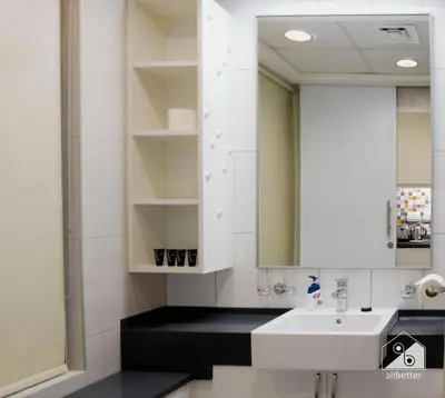 a bathroom with a white sink and a mirror at Stunning Palm Views Apt on the beach Dubai in Dubai