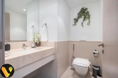 a bathroom with a toilet and a sink and a mirror at Vogue Downtown Act Two near Burj Khalifa and Dubai Mall, Three Bedroom Plus Kids room Apartment with Balcony and Burj Khalifa View, Access to all Amenities in Dubai