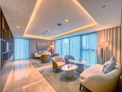 a hotel lobby with chairs and tables and windows at Vogue Downtown Act Two near Burj Khalifa and Dubai Mall, Three Bedroom Plus Kids room Apartment with Balcony and Burj Khalifa View, Access to all Amenities in Dubai