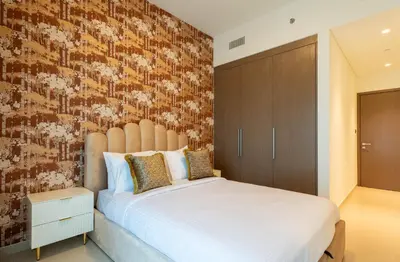 a bedroom with a large white bed and a brick wall at INA Homes - Act 1 Full Burj Khalifa and Fountain Views in Dubai