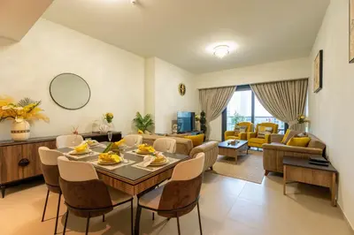 a living room with a table and chairs at INA Homes - Act 1 Full Burj Khalifa and Fountain Views in Dubai