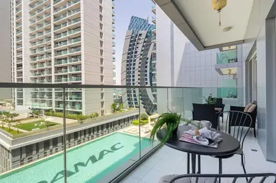a balcony with a table and a swimming pool at Frank Porter - Majestine 1 in Dubai