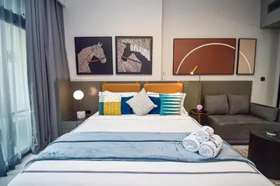a bedroom with a large bed and a couch at Luxury Escapes - Large & Brand New Studio Apt Business Bay - MAG in Dubai