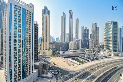 a city with many tall buildings and a highway at Luxury Escapes - Large & Brand New Studio Apt Business Bay - MAG in Dubai