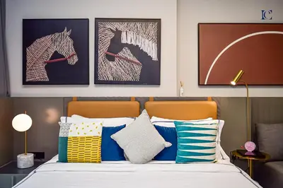 a bedroom with a bed with blue and white pillows at Luxury Escapes - Large & Brand New Studio Apt Business Bay - MAG in Dubai