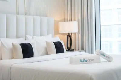 two beds in a hotel room with white sheets and pillows at Elegant seaside living 3-bedroom Emaar Beachfront by Suiteable in Dubai