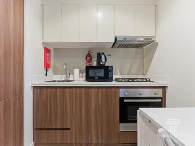 a small kitchen with a microwave and a stove at Cozy 1 BR in Business Bay Dubai by GP Holiday Homes in Dubai