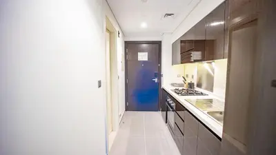 a kitchen with a stove and a blue door at Luxurious Studio in Business Bay by Tanami Holiday Homes in Dubai