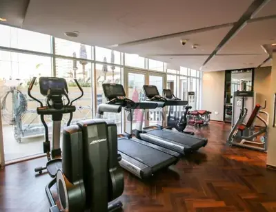 a gym with rows of treadmills and elliptical machines at Luxurious Studio in Business Bay by Tanami Holiday Homes in Dubai