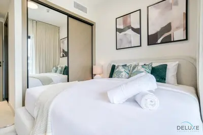 a bedroom with a large white bed with towels on it at Pristine 1BR at Binghatti Creek Al Jadaf by Deluxe Holiday Homes in Dubai