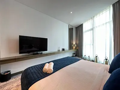a hotel room with a bed with two slippers on it at Business Bay Modern studio with a Canal view at DAMAC Maison Prive 1616 in Dubai