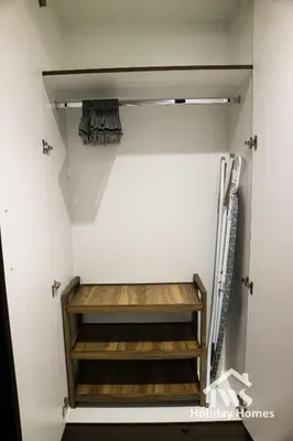 a walk in closet with wooden shelves at The Urban Oasis - Bliss in Dubai