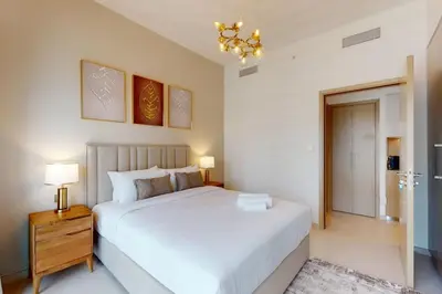a bedroom with a large white bed and a chandelier at Burj Royale - Classic One Bedroom in Dubai
