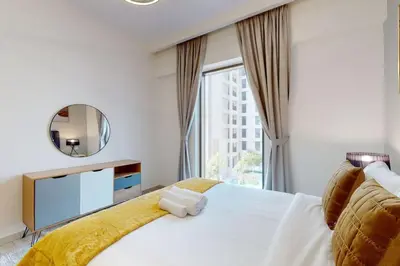 a bedroom with a large bed and a mirror at Vacationer I Premium One Bed with Skyline Views I Summer Creek Beach Tower 2, Dubai Creek Harbour in Dubai