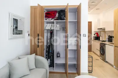 a living room with a couch and a closet at Le Petit Village !Cozy Yet Spacious Studio Apartment! in Dubai