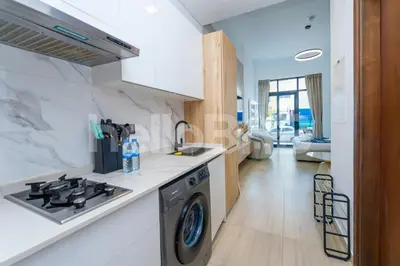 a kitchen with a stove top oven next to a sink at Le Petit Village !Cozy Yet Spacious Studio Apartment! in Dubai