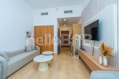 a living room with a couch and a table at Le Petit Village !Cozy Yet Spacious Studio Apartment! in Dubai