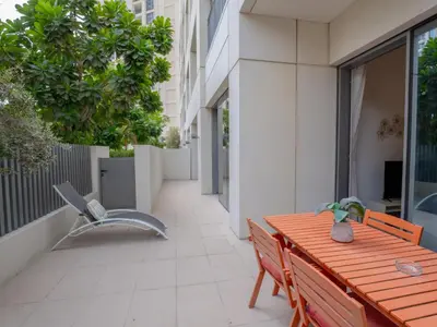 a wooden table and a bench in a courtyard at EasyGo - Exceptional 2BDR- Large Terrace-Pool Access in Dubai