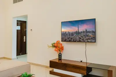 a living room with a tv on a wall at RH - Spacious & Bright 01BR, Walk away to mall of Emirates in Dubai