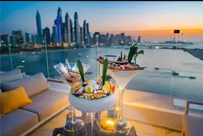 two martini glasses filled with food on a balcony with a city at Five Palm Super Luxury Apt with Full Sea Views in Dubai