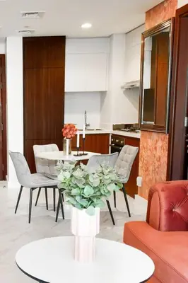 a living room with a table and chairs and a kitchen at Reva tower- 2BR Dubai mall walking & canal facing in Dubai