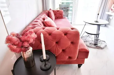 a living room with a red couch and a table at Reva tower- 2BR Dubai mall walking & canal facing in Dubai