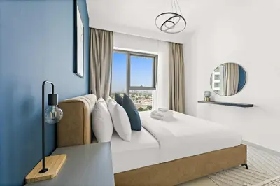 a bedroom with a bed with blue walls and a window at Silkhaus chic 1BDR in the heart of Downtown in new tower in Dubai