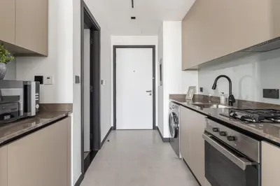 a white kitchen with a sink and a stove at Frank Porter - 15 Northside Tower 1 in Dubai
